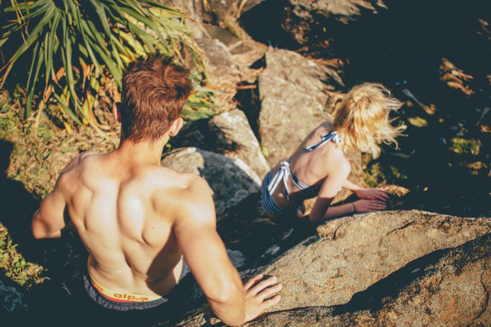 A man and a woman going down the rocky terrain