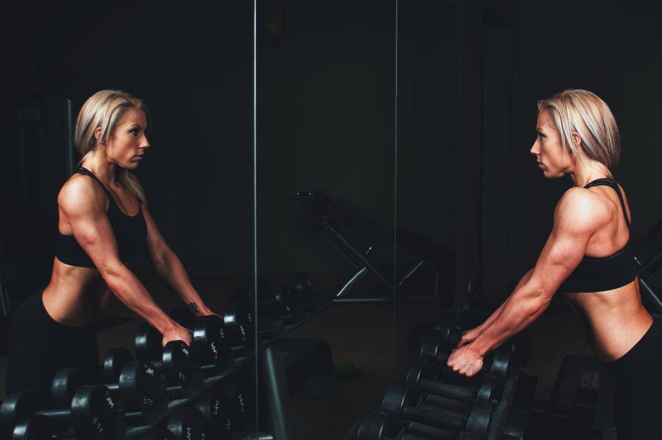Woman with weights looking in the mirror