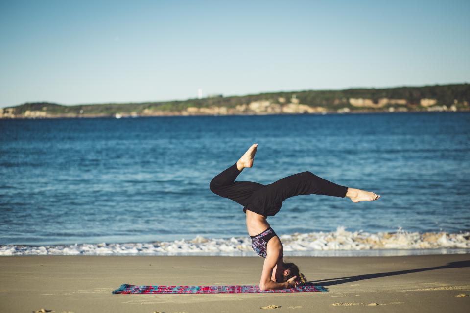 Women doing yoga on the beach