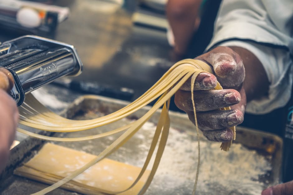 Man holding homemade pasta in his hand