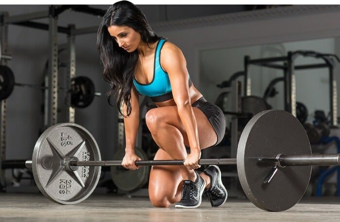 Woman doing deadlifts in a gym
