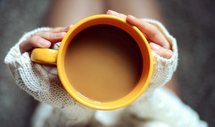 Girl holding orange cup of coffee