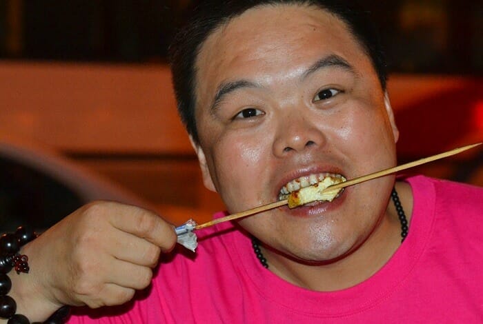 Chinese man eating tofu