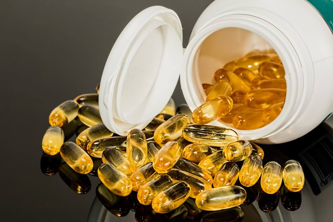 Supplement capsules spilling out of the bottle.