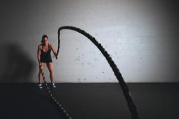 woman using battle ropes