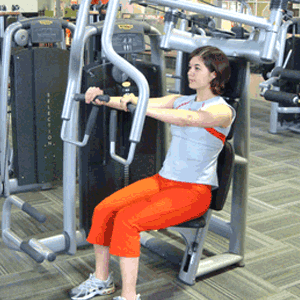Woman exercising on a seated chest press machine