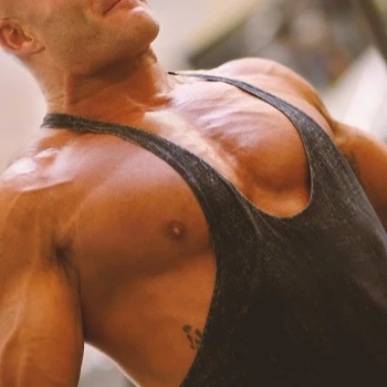 A person with wide and broad shoulders posing in the gym