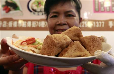 Woman serving tofu dish in restaurant