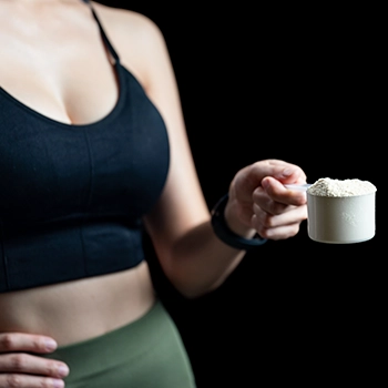 Woman holding a scoop of Lactose Free protein powder