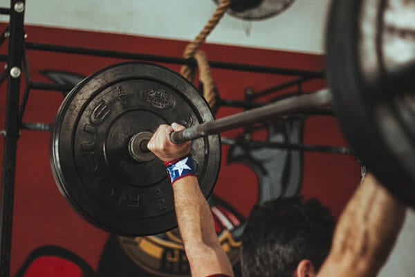 A man in the gym lifting a barbell