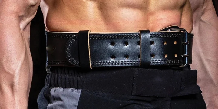 A close up shot of a man wearing a weightlifting belt