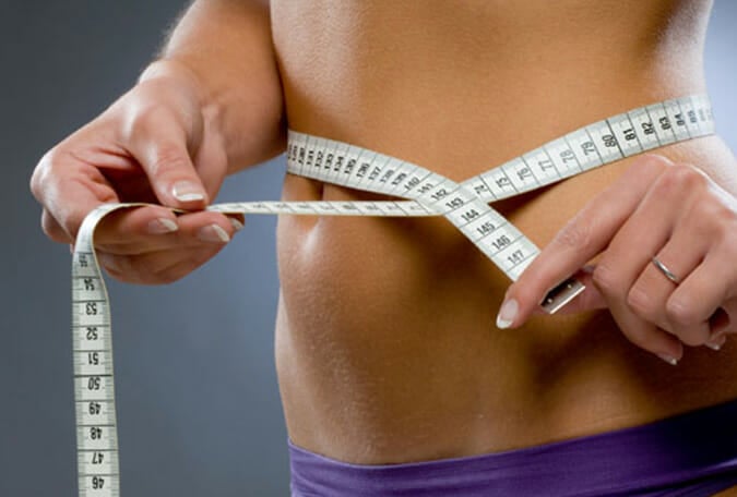 A woman measuring her waist