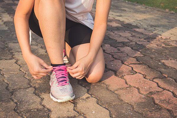 A woman lacing up her shoes