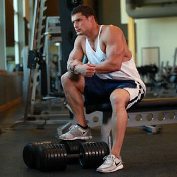 man sitting on a bench at the gym