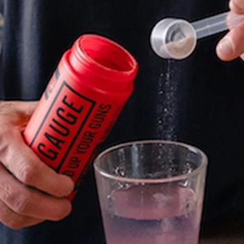 Pouring a workout supplement on a glass of water