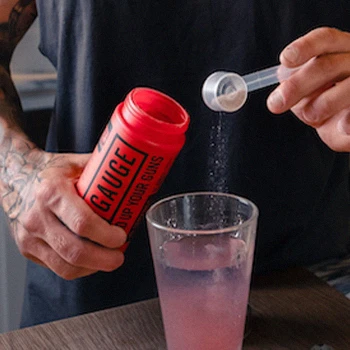 Pouring a workout supplement on a glass of water