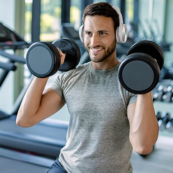 A smiling young man working out in a gym