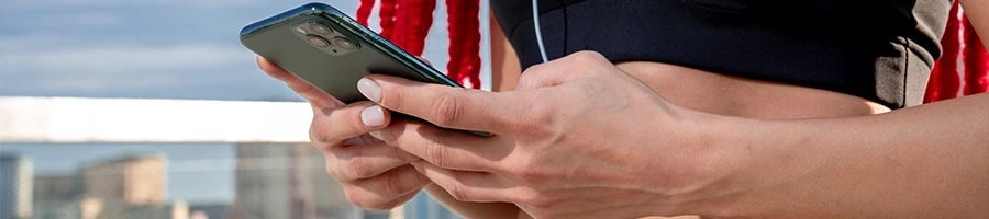 A woman holding her phone reading FAQs about best green superfood powders