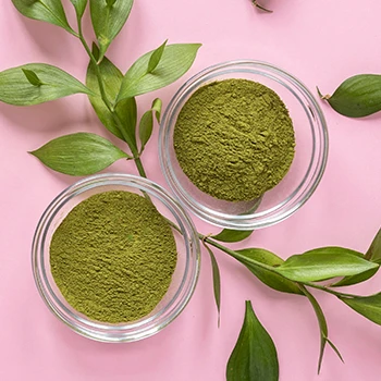 A top view of green tea leaves and powder