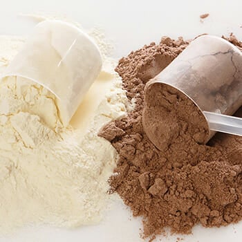 A scoop of vanilla whey protein and chocolate whey protein on a table