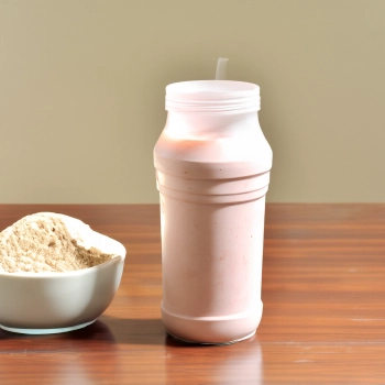 Protein powder on a small bowl and protein mixed with water on a container