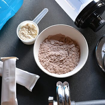 Top view of protein powder in a bowl and on a spoon scoop