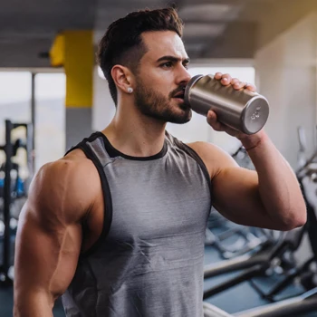 A muscular man drinking mass gainer