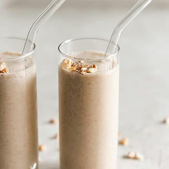 Close up shot of a cold milk shake with a glass straw