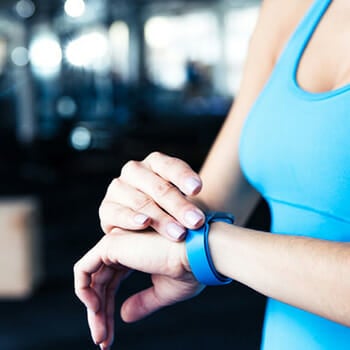 A woman checking out her watch at the gym