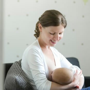 A pregnant woman breastfeeding her baby