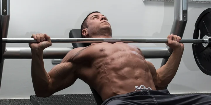 A focused body builder doing an inclined bench press after taking pre workout for focus