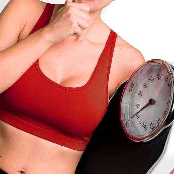 A fit woman holding a weighing scale
