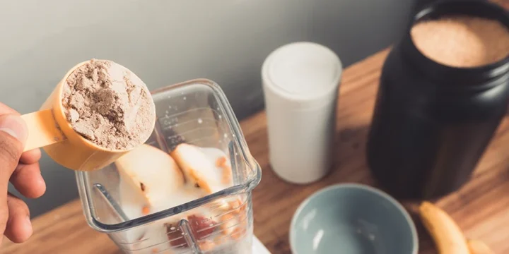 A person making a dairy-free meal replacement shake at home