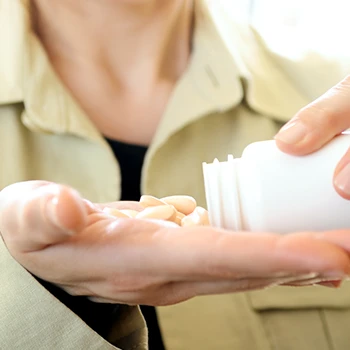 A woman pouring supplements on her hands