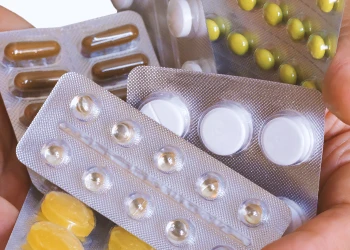 A bunch of pills on a person's hand