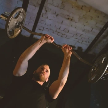 Man doing tricep curls on bench press