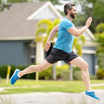 An energetic man running outdoors