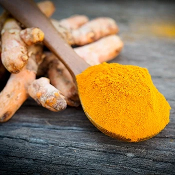 A close up shot of turmeric on a spoon