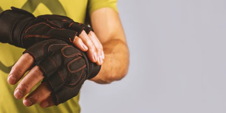 A person putting on weight lifting gloves