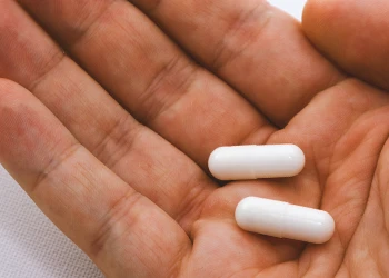 A person holding two pills