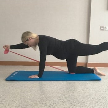 woman doing a kneeling superman workout