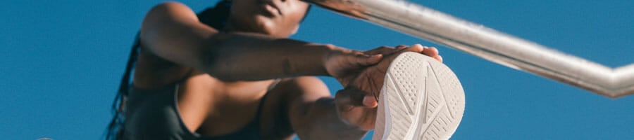 woman doing leg stretches outdoors