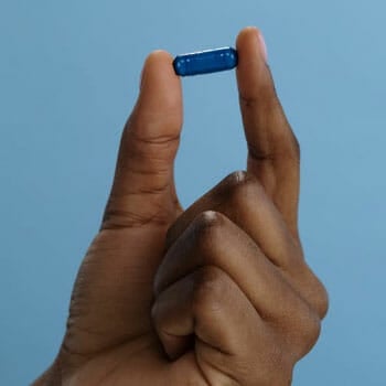 A man holding a pill