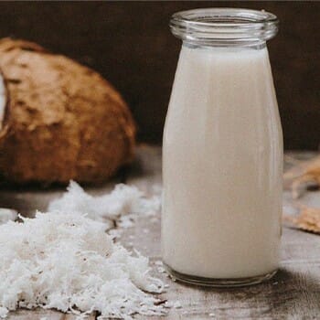 Coconut milk on a bottle and coconut crumbs