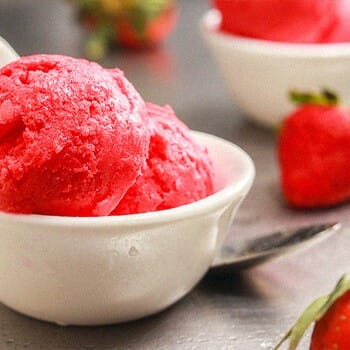 Two scoop of a strawberry flavored sorbet in a bowl