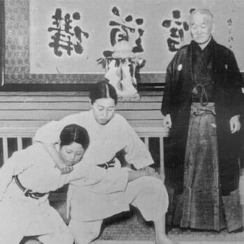 a vintage image of jigoro kano with his students