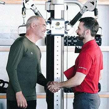 A seller shaking hands with a buyer at a home gym