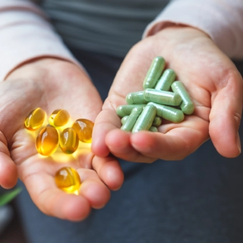 A person holding supplement capsules on both hands