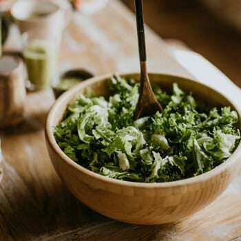 green salad in a bowl with a spoon on it