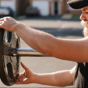 man fixing a barbell plate